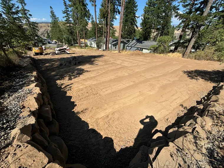 Rockery retaining wall around a freshly graded, level yard